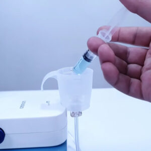 Mão colocando medicamento num nebulizador Omron