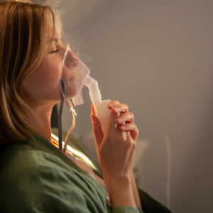 Mulher de vista lateral utilizando nebulizador